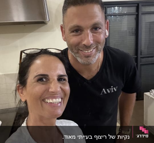 שני אנשים מחייכים במטבח, אין אלמנטים של ניקיון נראים
